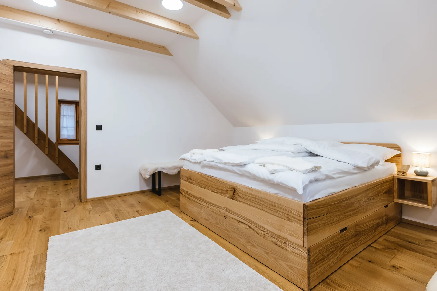 King bedroom with exposed wooden beams, Alpine House 77, Podkoren