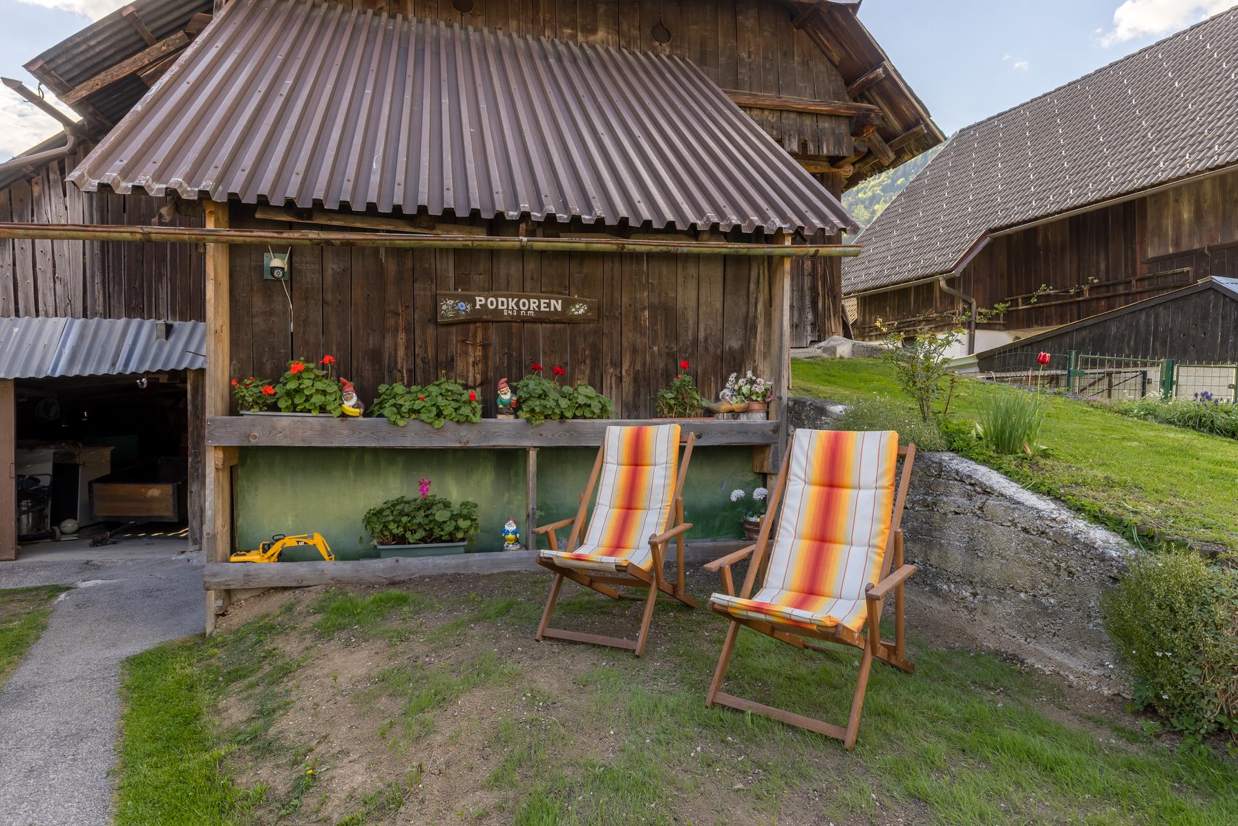 Garden deck chairs by traditional barn with mountain views