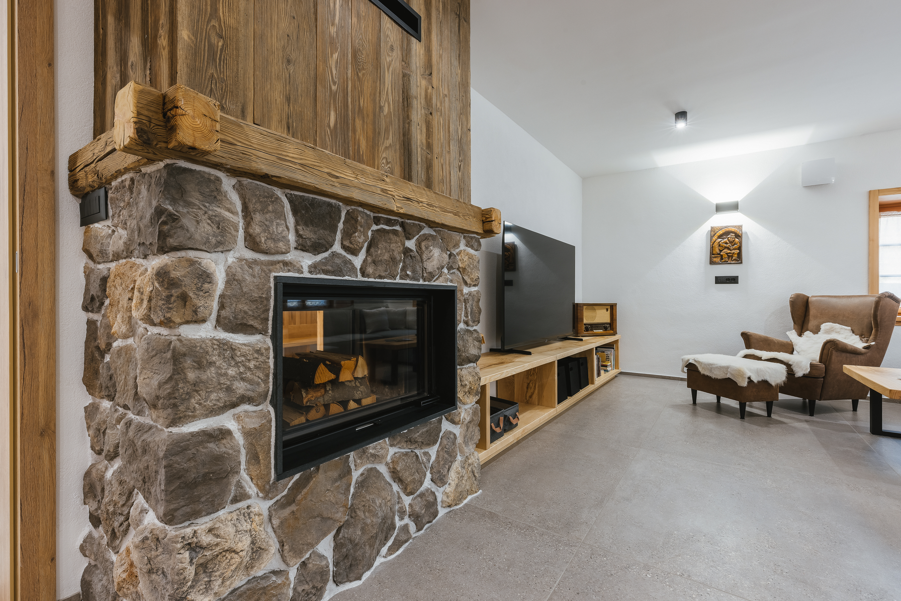 Stone fireplace close-up with wooden mantel