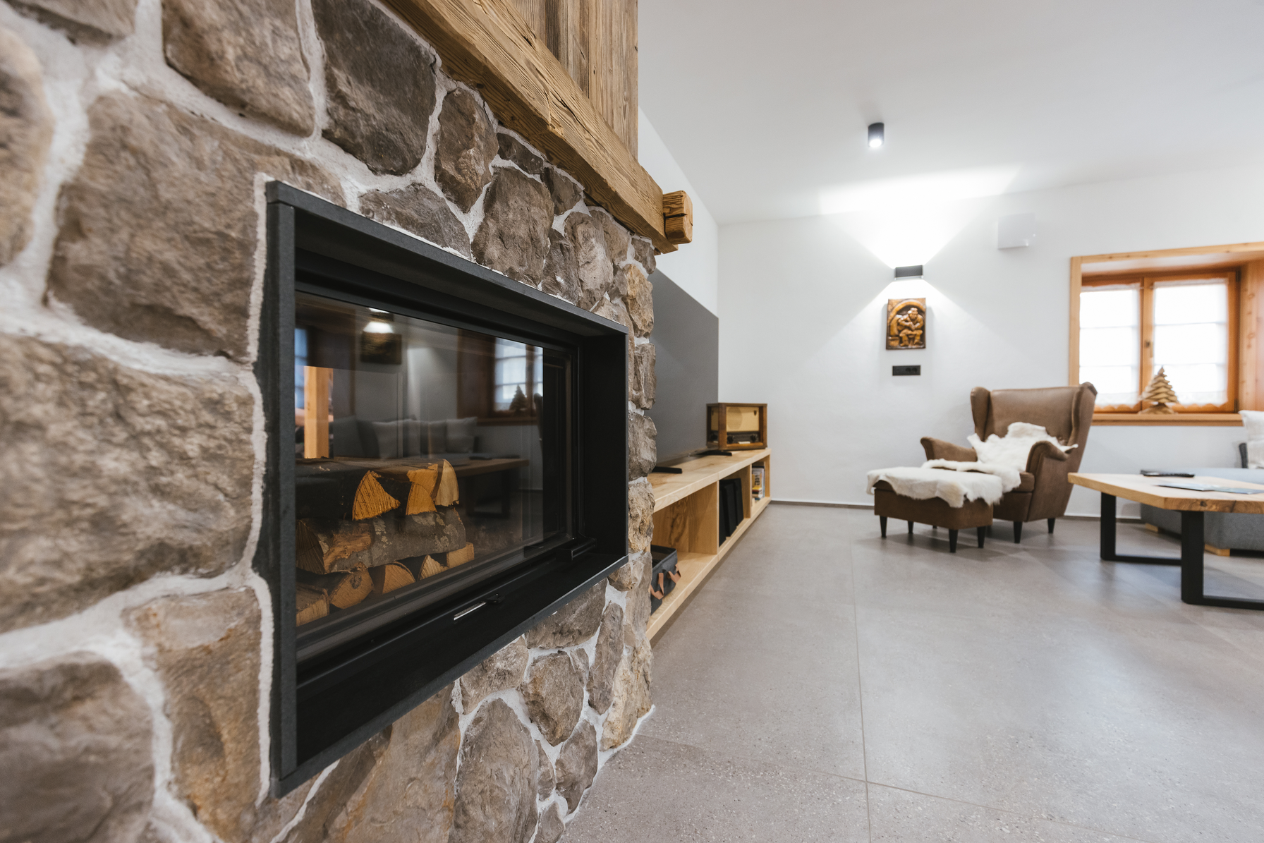 Stone fireplace with wooden beam mantel, side view
