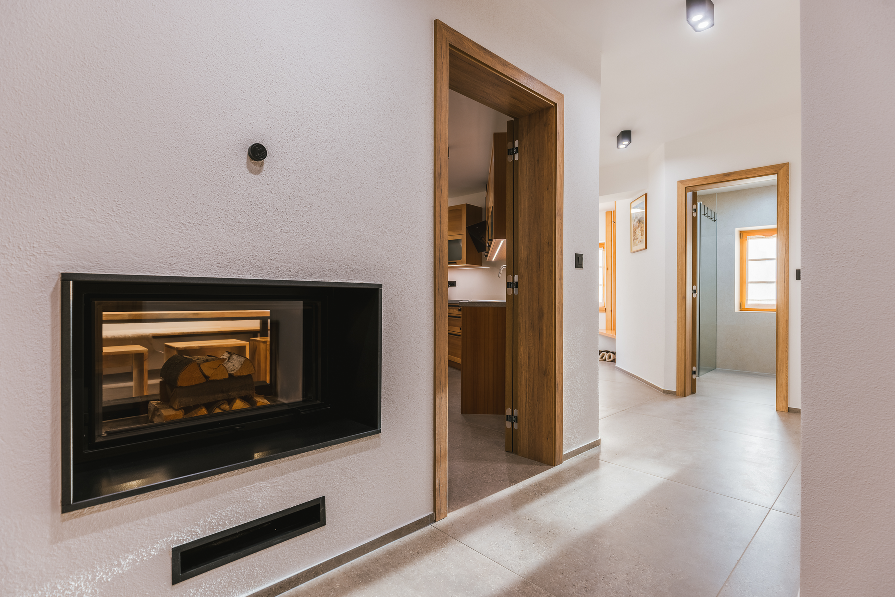 Hallway with fireplace visible through glass wall