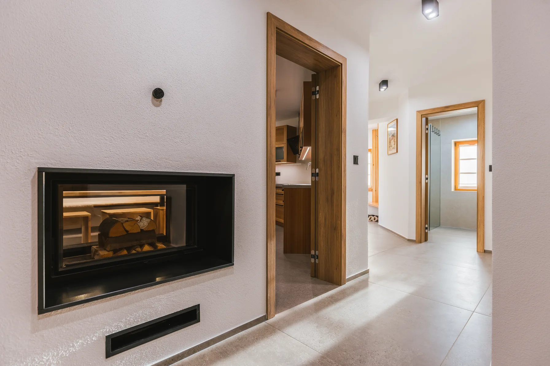 Hallway with fireplace visible through glass wall