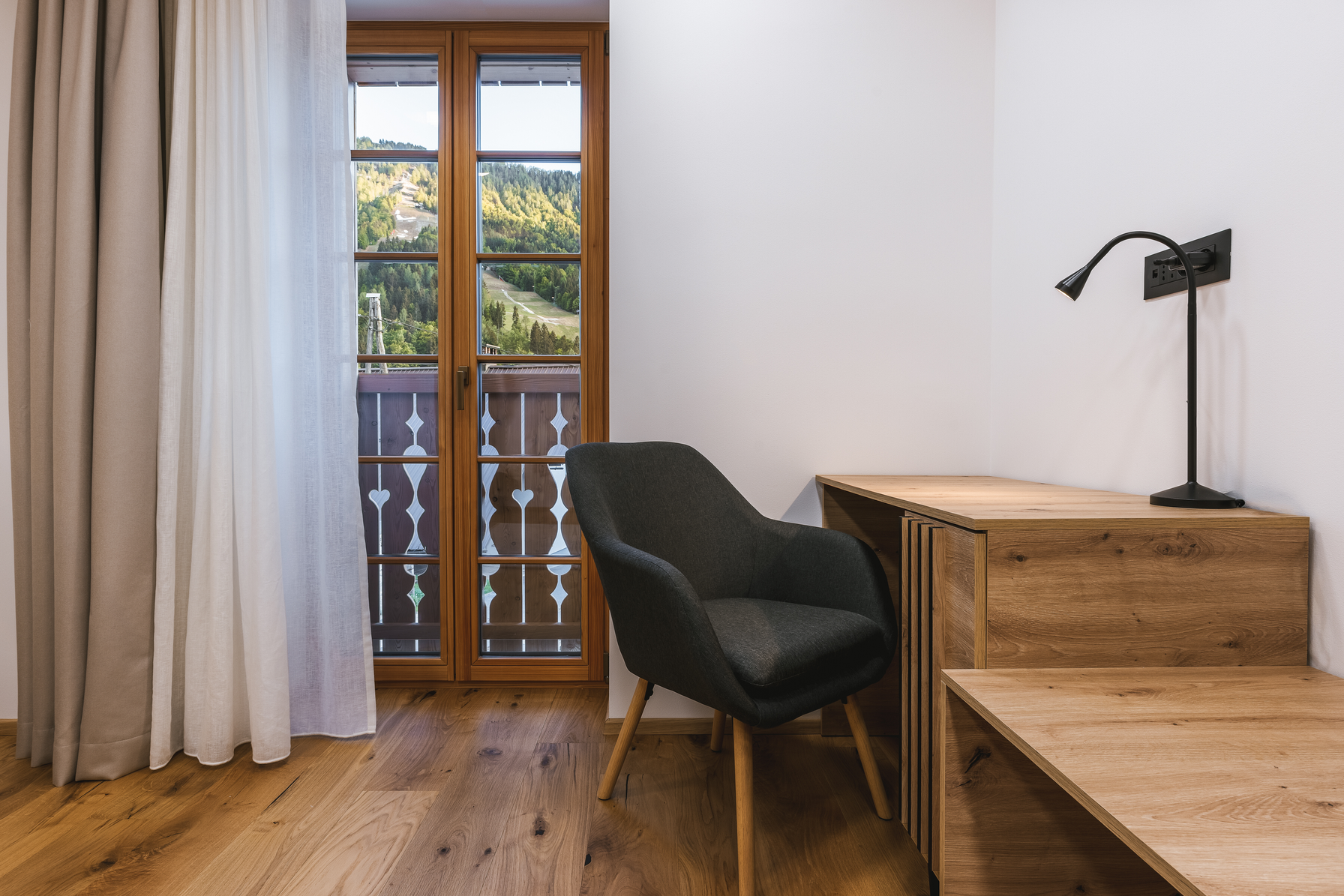 Bedroom desk with mountain and ski slope view through balcony