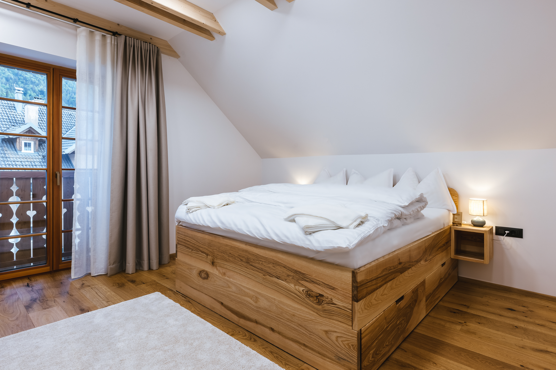 King bedroom with balcony doors and village view